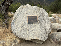 Plaque dedicating establishment of Wilderness Gardens on a large granite boulder.